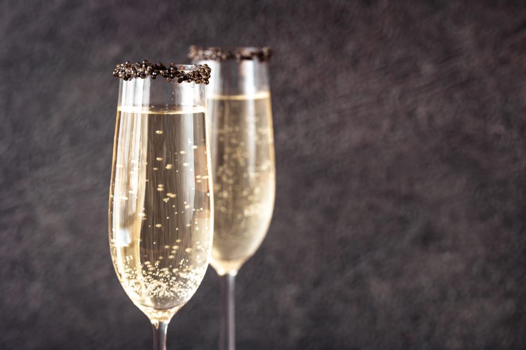 Flutes de Champagne avec du caviar sur les rebords